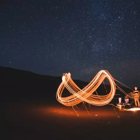a campfire in the night with infinity logo
