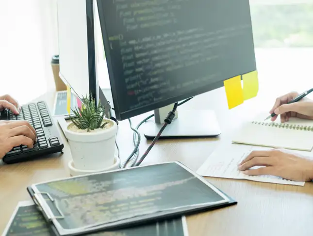 cropped-hands-programmers-coding-computers-office.jpg