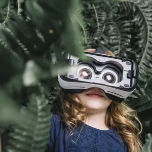 smiling-blonde-little-girl-using-virtual-headset-standing-green-plant.jpg